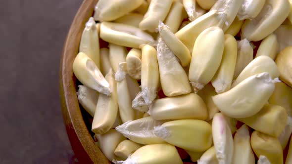 Cancha corn seeds on rustic wooden bowl. Dried maize. Macro