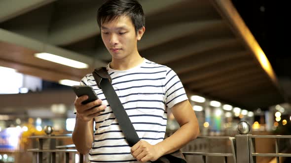 Young man use of mobile phone in the city 