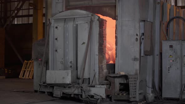 Robotic Retractable Furnace with Red-hot Metal Workpieces in Foundry. Room for Manufacture of Metal