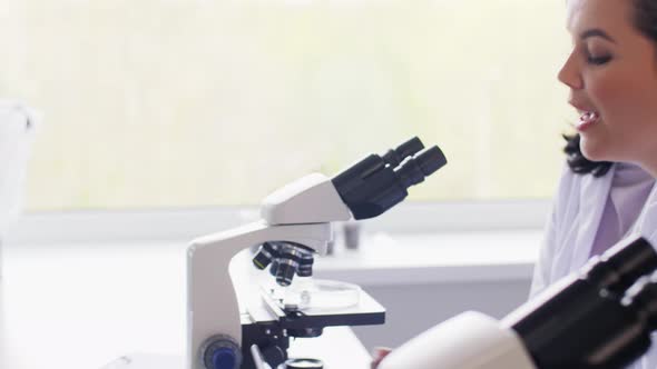 Scientists with Microscopes Working in Laboratory