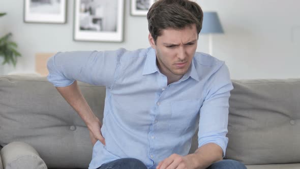 Man with Spinal Back Pain Sitting on Couch