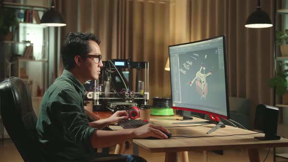 Asian Engineer Working On Personal Computer And 3D Printer, Screen Shows Cad Software With 3D Drone