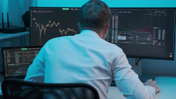 Close up of young Caucasian man trader working at monitor computer and browsing online