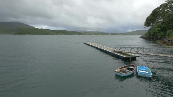 Two rowboats moored by a wooden dock