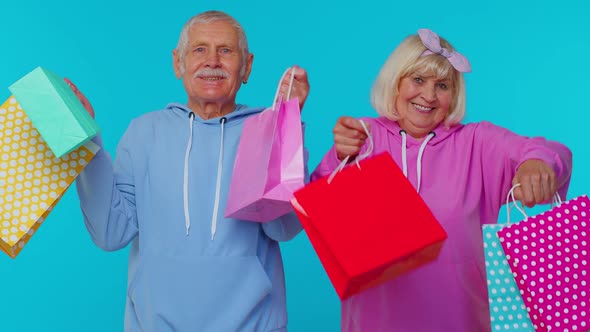 Senior Grandmother Grandfather Showing Shopping Bags Advertising Price Discounts Black Friday Sale