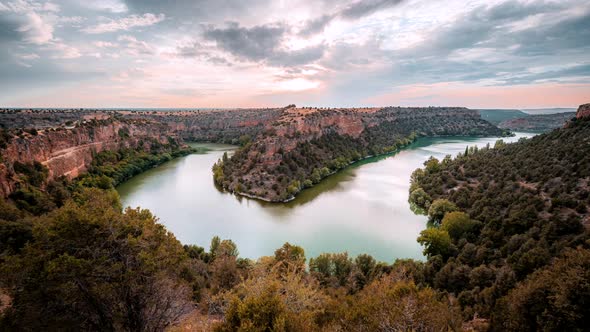 Natural park with mountains and river under cloudy sky