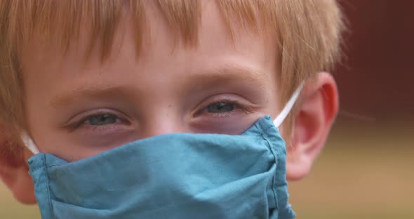 Close up portrait of a cute little boy wearing a mask to help prevent the spread of coronavirus.