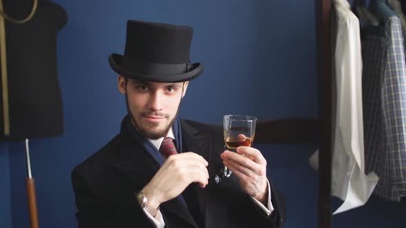 Handsome Young Man in a Classic Suit Drinking Whiskey in Restaurant.