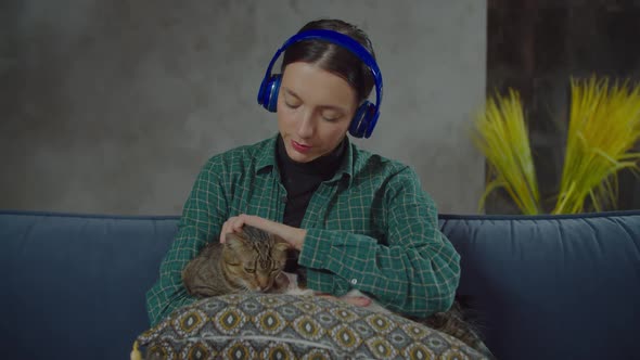 Woman in Headphones Relaxing with Cats at Home