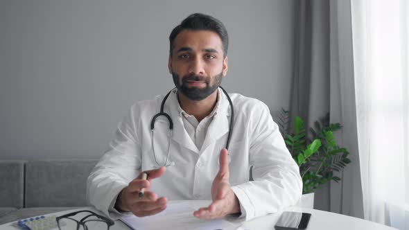 Adult Indian Male Doctor Wear White Coat and Stethoscope Make Online Video Call