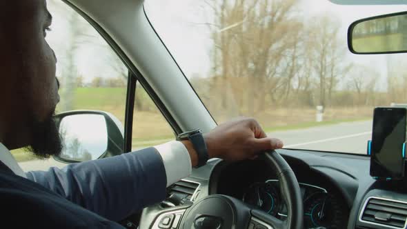 Confident African American Man in Suit Driving Car on Freeway