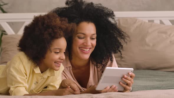 African American Woman and Litle Girl Talking on Video Call Using Digital Tablet