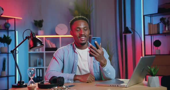 Black-Skinned Guy Enjoying Pleasant Video Conversation on Mobile at Home