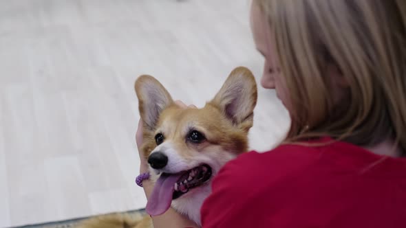 Young Teen Girl Hugging Corgi Dog with Love