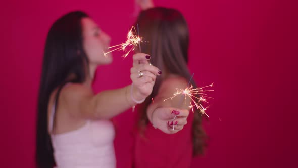 Two Young Women in Love Enjoy Holiday Atmosphere, Kissing and Burning Sparklers