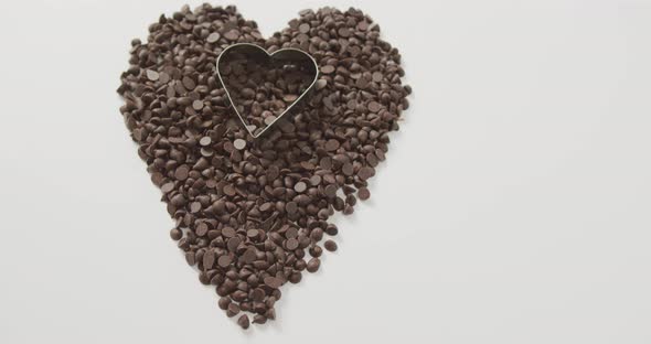 Video of heart formed with chocolate chip and copy space over white background