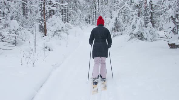 A woman walking through deep snow in forest