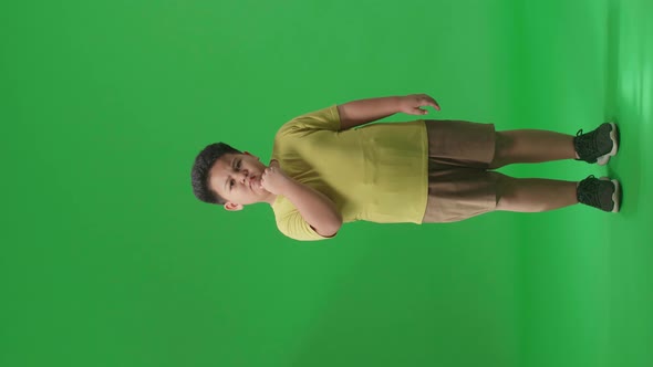 Full Body Of Asian Little Boy Thinking Then Raising His Index Finger On Green Screen In The Studio