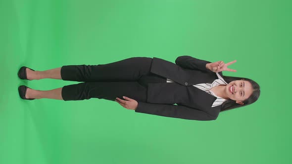 Full Body Of Asian Business Woman Showing Gesture Peace And Smiling While Standing On Green Screen