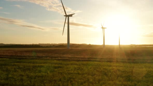 Three large wind turbines at sunrise