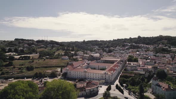 Gothic Cistercian art masterpiece , the Alcobaça monastery against cityscape and forest, Portugal