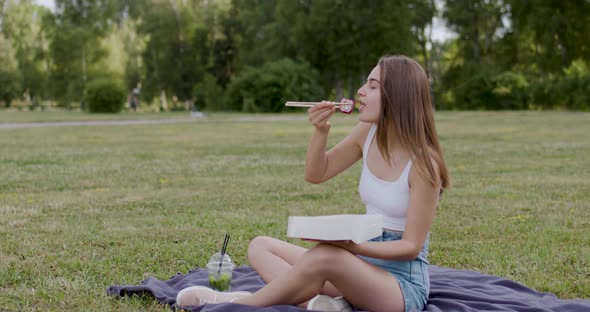 a Young Woman Dressed in a White Tshirt and Blue Aprons Went Out in Nature to Eat the Most