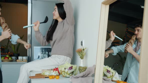 Slow Motion of Joyful Couple Dancing and Singing Enjoying Music in Kitchen at Home