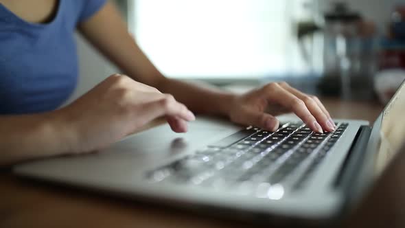 Woman typing on laptop computer at home