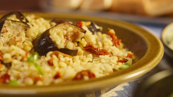 Sprinkling Greenery on Bulgur with Eggplant Closeup