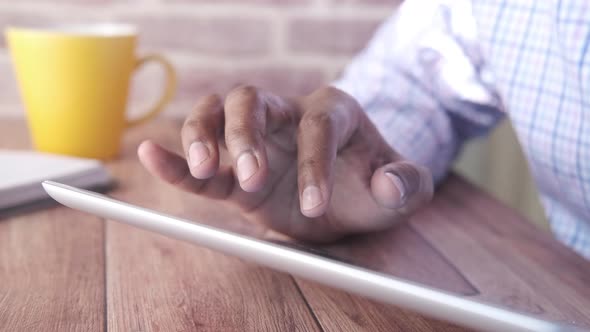 Close Up of Businessman Hand Using Digital Tablet on Office Desk