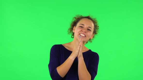 Portrait of Curly Woman Keeping Palm Together and Asking for Something. Green Screen