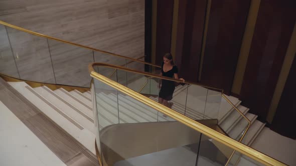 Girl in a Beautiful Evening Dress Goes Up the Stairs