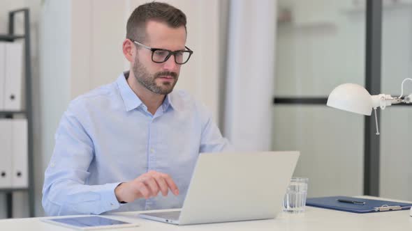 Middle Aged Man Reacting To Failure While Using Laptop at Work