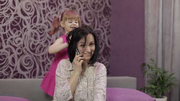 Mother Trying Talk on Smartphone. Stressed By Noisy Running, Jumping Child Kid