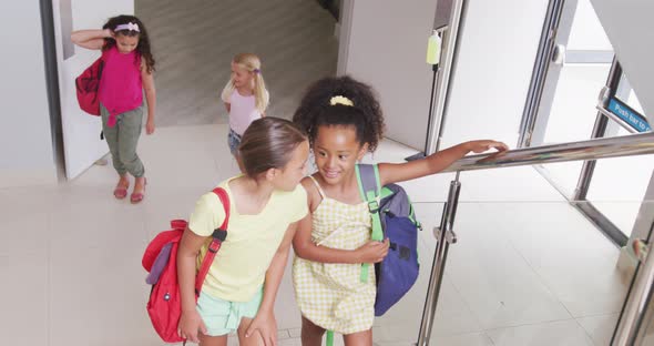 Video of happy diverse girls walking upstairs at school and talking