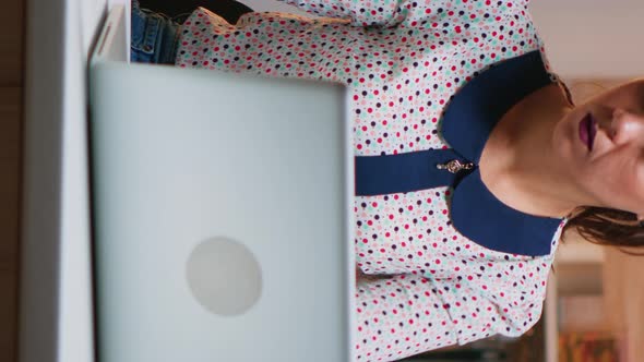 Vertical Video: Tired Lady Working on Laptop in the Kitchen