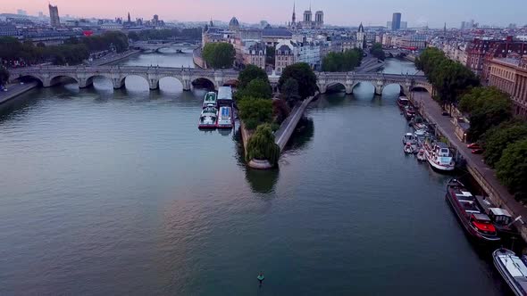 Flying over Seine river towards Ile de la Cite, Notre Dame cathedral and Pont Neuf Bridge in Paris,