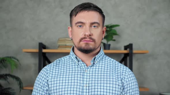 Close up bearded businessman standing in modern office turns head looking camera