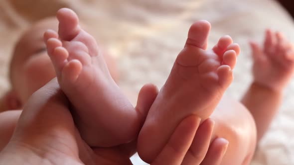 Mother Holding Baby Feet in Hands