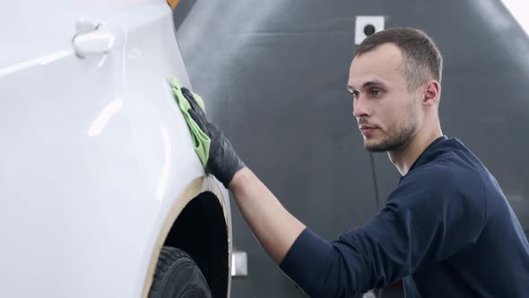 Man Polish a Car in a Garage