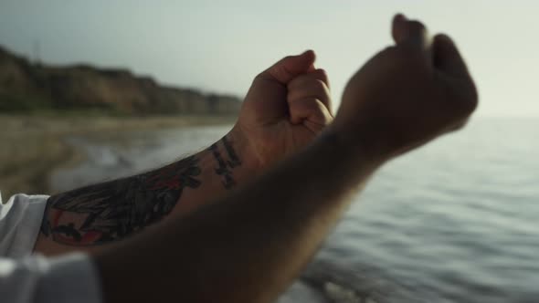 Tattooed Man Hands Doing Warmup at Sunset Close Up