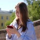 Young woman using smartphone outdoor. Girl looking at mobile phone - VideoHive Item for Sale