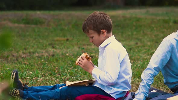 Young Guy Reads Book Eating Burger During Lunch Break