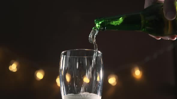 Close Up of Man Pouring Beer Into a Glass