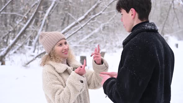 A Young Couple Walks in the Winter in the Forest