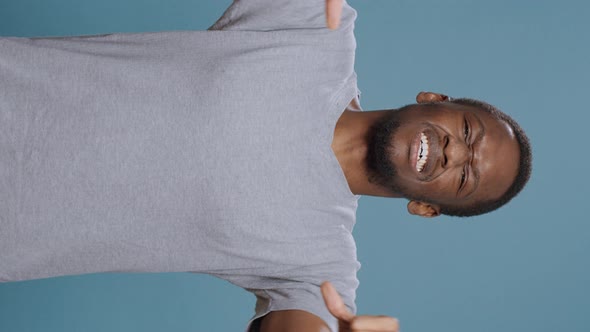 Vertical Video Disappointed Person Showing Thumbs Down Symbol in Studio