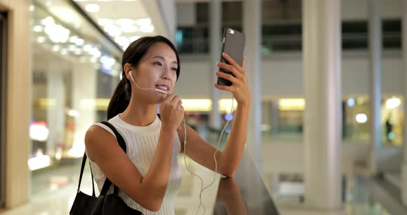 Woman using smart phone with shopping bags 