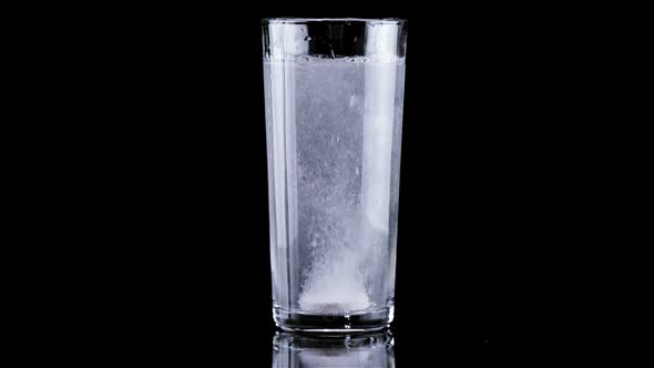 Effervescent Tablet Falling in Glass of Water