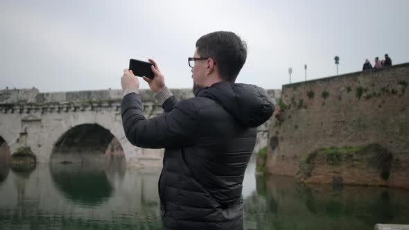 Man Films Ancient Atchitecture Reflecting in River