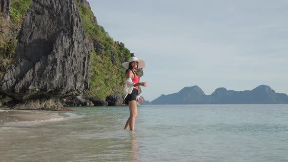 Woman Smiling And Walking In Sea On Entalula Beach